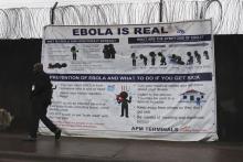 A man walks by a sign that reads "Ebola is real" in Monrovia, Liberia, October 21, 2014. PHOTO BY REUTERS/James Giahyue