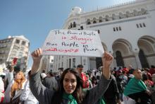 A demonstrator holds up a sign as teachers and students take part in a protest demanding immediate political change in Algiers, Algeria, March 13, 2019. PHOTO BY REUTERS/Zohra Bensemra