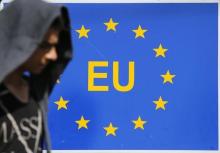 A migrant walks next to an EU sign at the border with Serbia in Tovarnik, Croatia, September 17, 2015. PHOTO BY REUTERS/Antonio Bronic