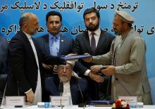 Mohammad Amin Karim (R), representative of Gulbuddin Hekmatyar, and Afghanistan national security adviser Mohammad Hanif Atmar (L) hold a document after signing a peace deal in Kabul, Afghanistan, September 22, 2016. PHOTO BY REUTERS/Omar Sobhan
