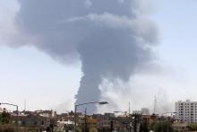 Smoke rises after rockets fired by one of Libya's militias struck and ignited a tank in Tripoli, August 2, 2014. PHOTO BY REUTERS/Hani Amara