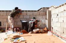 A sniper from forces aligned with Libya's new unity government shoots while his comrade uses binoculars to scan the area looking for an Islamic State position in the Zaafran area in Sirte, June 30, 2016. PHOTO BY REUTERS/Ismail Zitouny