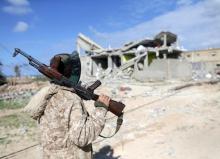 A member of East Libyan forces holds his weapon as he stands in front of a destroyed house in Ganfouda district in Benghazi, Libya, January 28, 2017. PHOTO BY REUTERS/Esam Omran Al-Fetori