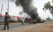 Soldiers stand near a burning barricade during demonstrations by protesters against the ruling CNDD-FDD party's decision to allow Burundian President Pierre Nkurunziza to run for a third five-year term in office, in Bujumbura, May 7, 2015. PHOTO BY REUTERS/Jean Pierre Aime Harerimana