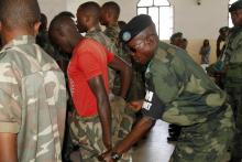 A Congolese soldier is stripped of his rank and uniform after the mass trial of 39 soldiers inside a military court in Goma in eastern Democratic Republic of Congo