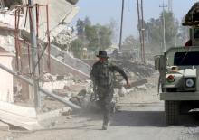 An Iraqi soldier runs through the city of Qaraqosh, as troops search for any Islamic State militants still in the area, near Mosul in Iraq, October 30, 2016. PHOTO BY REUTERS/Ahmed Jadallah