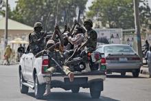 Soldiers and people carrying machetes ride on the back of a vehicle along a street in Gombe January 30, 2015. Picture taken, January 30, 2015. PHOTO BY REUTERS/ Afolabi Sotunde