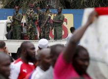 Soldiers stand as mourners carry the casket of Zedi Feruzi, the head of opposition party UPD in Bujumbura, Burundi, May 24, 2015. PHOTO BY REUTERS/Goran Tomasevic