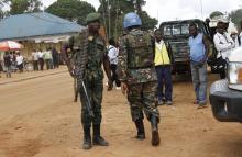 A peacekeeper serving in the United Nations Organization Stabilization Mission in the Democratic Republic of the Congo (MONUSCO) and a Congolese soldier stand guard as residents gather following recent demonstrations in Beni in North Kivu province, October 23, 2014. PHOTO BY REUTERS/Kenny Katombe