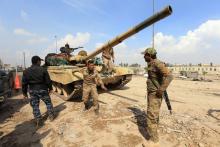 Members of Iraqi rapid response forces and a member of federal police gather next to a tank during a battle against Islamic State militants at the Bab al-Tob area in Mosul, Iraq, March 14, 2017. PHOTO BY REUTERS/Ari Jalal