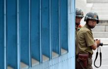 North Korean soldiers watch the south side as the United Nations Command officials visit after a commemorative ceremony for the 64th anniversary of the Korean armistice at the truce village of Panmunjom in the Demilitarized Zone (DMZ) dividing the two Koreas, July 27, 2017. PHOTO BY REUTERS/Jung Yeon-Je