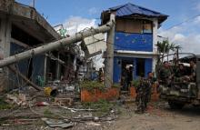 Soldiers stand on guard in front of damaged buildings after government troops cleared the area from pro-Islamic State militant groups inside a war-torn area in Bangolo town, Marawi City, southern Philippines, October 23, 2017. PHOTO BY REUTERS/Romeo Ranoco