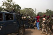 A crowd chases a Gendamerie officer, who managed to escape in the back of a vehicle after he was accused of being a supporter of the ousted Seleka fighters, in the capital Bangui