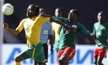 South Africa's Lerato Chabangu (L) is challenged by Burkina Faso's Zerbo Adama during the inaugural Nelson Mandela Sport and Culture Day at the soccer city stadium in Soweto