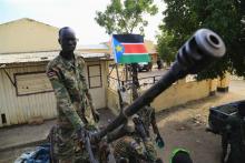 A South Sudan army soldier stands next to a machine gun mounted on a truck in Malakal town, 497km (308 miles) northeast of capital Juba