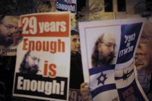 Israelis hold placards depicting Jonathan Pollard during a protest calling for his release from a U.S. prison, outside U.S. Secretary of State John Kerry's hotel in Jerusalem