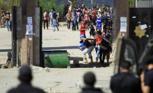 Student supporters of the Muslim Brotherhood and ousted President Mohamed Mursi throw stones at riot police during clashes in front of the Al-Azhar University campus, in Cairo's Nasr City district