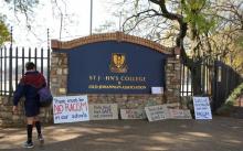 A student reads placards left at the entrance of the St. John's College in Johannesburg, South Africa, July 28, 2017. PHOTO BY REUTERS/Siphiwe Sibeko