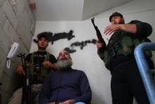 Sunni Muslim fighters stand with their weapons inside a building in Tripoli, northern Lebanon