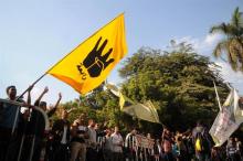 Students of Cairo University, who are supporters of the Muslim Brotherhood and ousted Egyptian President Mohamed Mursi, wave a flag bearing the "Rabaa" sign during a protest against the military and interior ministry