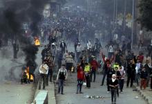 Supporters of the Muslim Brotherhood and ousted Egyptian President Mohamed Mursi gesture near burning tyres during clashes with riot police in Cairo