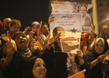 Supporters of Abdel Fattah al-Sisi hold a poster of him as they celebrate at Tahrir square in Cairo