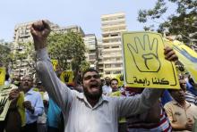 Members of the Muslim Brotherhood and supporters of ousted Egyptian President Mohamed Mursi shout slogans against the military and the interior ministry as they make the "Rabaa" or "Four" gesture, during a protest march towards Mohandessin in Cairo, August 30, 2013. PHOTO BY REUTERS/Louafi Larbi