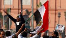 Supporters of Egypt's President Abdel Fattah al-Sisi hold up his portrait and an Egyptian flag as they shout slogans against the Muslim Brotherhood and other Islamist groups at Tahrir Square in Cairo, November 28, 2014. PHOTO BY REUTERS/Amr Abdallah Dalsh