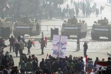 Supporters of Egypt's army and police cheer with national flags and Sisi posters in front of armoured personnel carriers (APC) standing guard in front of Tahrir square in Cairo, on the third anniversary of Egypt's uprising