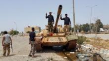 Members of the Libyan pro-government forces gesture as they stand on a tank in Benghazi, Libya, May 21, 2015. PHOTO BY REUTERS/Stringer