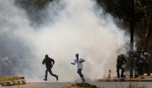 Supporters of the opposition National Super Alliance (NASA) coalition run as riot policemen fire tear gas to diperse them during a protest calling for the sacking of election board officials involved in August's cancelled presidential vote, in Nairobi, Kenya, October 6, 2017. PHOTO BY REUTERS/Thomas Mukoya