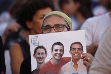 An Israeli woman holds a sign with images of three missing Israeli teenagers, at a rally in Rabin Square in the coastal city of Tel Aviv