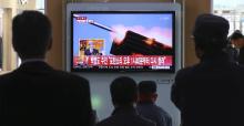 Passengers watch a television program showing reports on North Korea's plan to conduct live-fire drills, at a railway station in Seoul