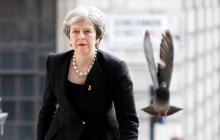 A pigeon flies ahead of British Prime Minister Theresa May as she arrives for an event in London, April 23, 2018. PHOTO BY REUTERS/Peter Nicholls