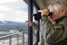 U.S. Secretary of Defense Chuck Hagel looks through a pair of binoculars to observe training at the Rodriguez Live Fire Complex (RLFC)