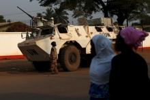 Women walk by a United Nations peacekeeping armoured vehicle guarding the outer perimeter of a compound of a school used as an electoral centre at the end of the presidential and legislative elections, in the mostly muslim PK5 neighbourhood of Bangui, Central African Republic, February 14, 2016. PHOTO BY REUTERS/Siegfried Modola