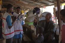 Workers from UNICEF and partners speak with families about how they can best protect themselves from the Ebola virus disease, at the Marche Niger, a market in Conakry, Guinea