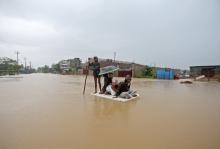 Villagers use a makeshift raft to cross a flooded area on the outskirts of Agartala, India, July 15, 2019. PHOTO BY REUTERS/Jayanta Dey