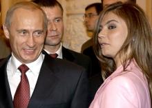 Russian President Vladimir Putin (L) smiles next to Russian gymnast Alina Kabaeva during a meeting with the Russian Olympic team at the Kremlin in Moscow, Russia, November 4, 2004. PHOTO BY REUTERS/ITAR-TASS