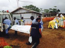 Volunteers carry bodies in a centre run by Medecins Sans Frontieres for Ebola patients in Kailahun