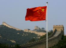 A Chinese flag flies in front of the Great Wall of China, located north of Beijing, August 18, 2007. PHOTO BY REUTERS/David Gray