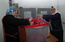 A woman casts her ballot during a vote to elect a constitution-drafting panel in Tripoli