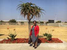 Mmaphuti Singo stands in front of some of the fauna planted through the Nasrec Memorial Park in Soweto, Johannesburg, South Africa, where she buried her husband last year, August 8 2019. PHOTO BY Thomson Reuters Foundation/Kim Harrisberg