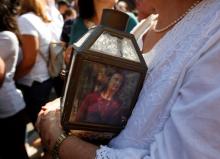 A woman holds a lantern with a picture of investigative journalist Daphne Caruana Galizia, who was assassinated in a car bomb attack, during a protest outside the law courts in Valletta, Malta, October 17, 2017. PHOTO BY REUTERS/Darrin Zammit Lupi