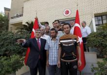 Faruk Kaymakci, the Turkish ambassador to Iraq (L) and Turkish workers stand in front of the Turkish embassy in Baghdad, Iraq, September 30, 2015. PHOTO BY REUTERS/Ahmed Saad