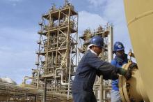 Workers perform maintenance on oil pipelines at the Sirte Oil Company in Brega