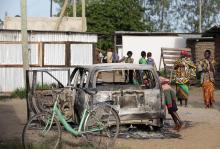 A boy peers into a burnt car at Kibaoni in Mpeketoni after unidentified gunmen attacked the coastal Kenyan town of Mpeketoni