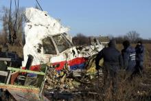 Local workers transport a piece of wreckage from Malaysia Airlines flight MH17 at the site of the plane crash near the village of Hrabove (Grabovo) in Donetsk region, eastern Ukraine, November 20, 2014. PHOTO BY REUTERS/Antonio Bronic