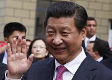 China's President Xi Jinping waves during a visit to a housing development in Caracas