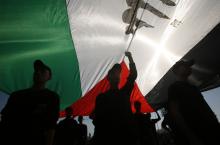 Palestinian youths stand under a large Palestinian flag during a military-style graduation ceremony after being trained at one of the Hamas-run Liberation Camps, in Gaza City, January 29, 2015. PHOTO BY REUTERS/Suhaib Salem